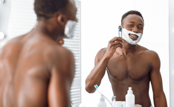 istock Black Man Shaving Face With Razor And Foam In Bathroom 1285272280