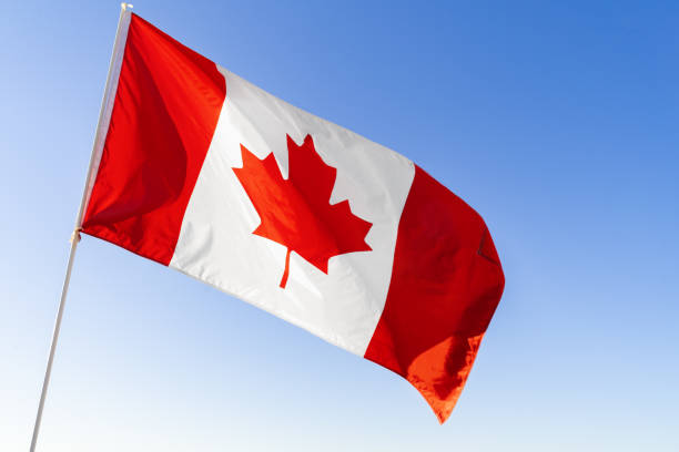 istock Flag of Canada waving against blue sky 1285272367