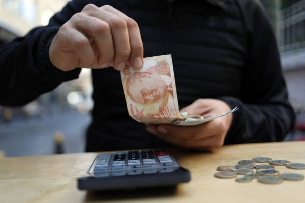 istock man doing financial transactions with calculator holding money 1285272528