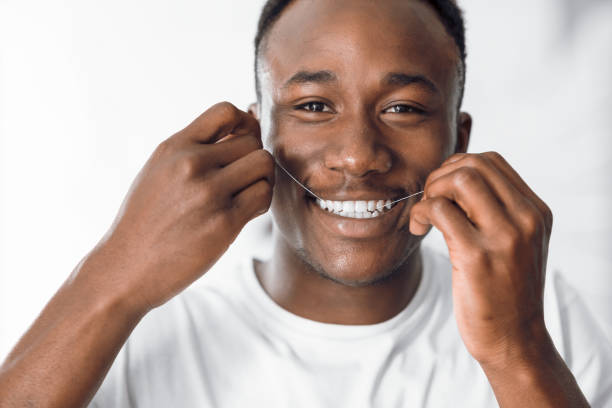 istock Happy Black Man Flossing Teeth Using Dental Floss In Bathroom 1285273734