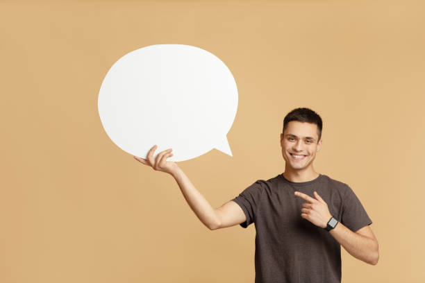 istock Smiling young guy with smart watch holds blank space for words in hand and points to abstract bubble 1285274147