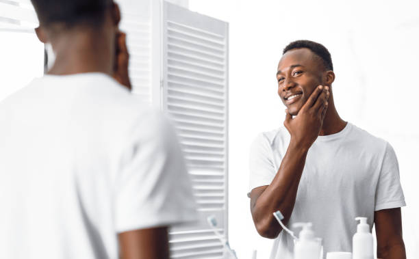 istock African Guy Touching Well-Shaved Smooth Face After Shaving In Bathroom 1285274337