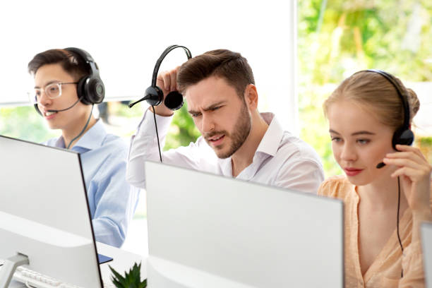istock Stressed call center operator listening to client's complaint at contemporary office 1285275359