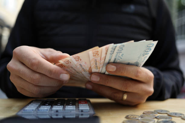 istock man doing financial transactions with calculator holding money 1285275565