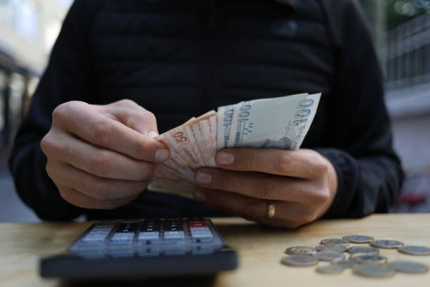 istock man doing financial transactions with calculator holding money 1285275953