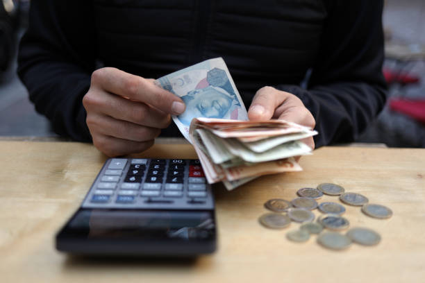 istock man doing financial transactions with calculator holding money 1285276836