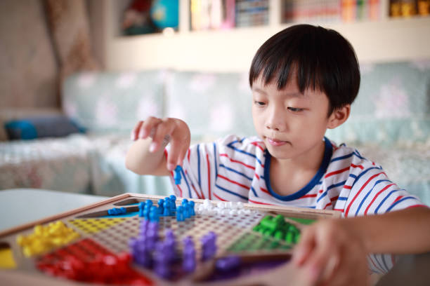 Kid playing chinese checkers Boy play Chinese checkers chinese checkers stock pictures, royalty-free photos & images