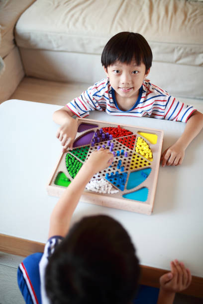Kid playing chinese checkers Boy play Chinese checkers chinese checkers stock pictures, royalty-free photos & images