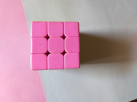 Top view of pink square cube rest on paper