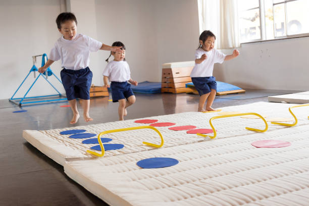 Gymnastics school for Japanese children Japanese children practicing mat exercise and horizontal bar horizontal bar stock pictures, royalty-free photos & images