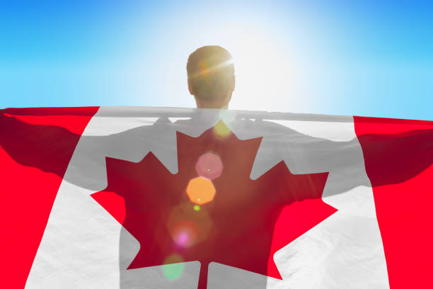istock Man with a flag of Canada standing in field 1285282849