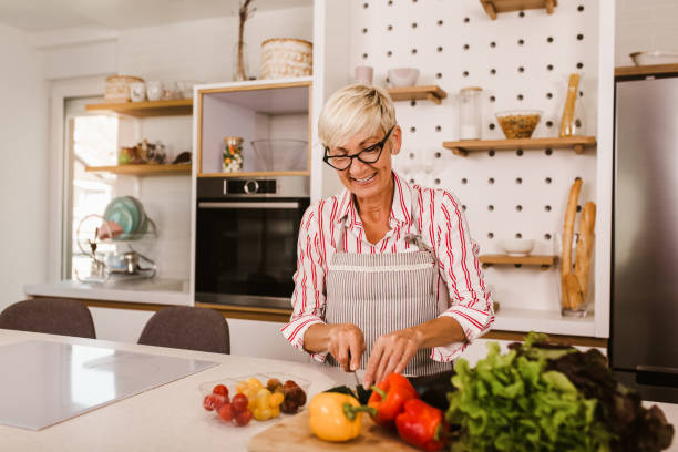 istock Happy senior woman cooking in her modern kitchen 1285283308