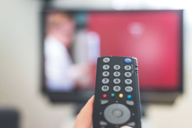 istock Male hand is holding TV remote control, streaming on a smart TV. 1285285915