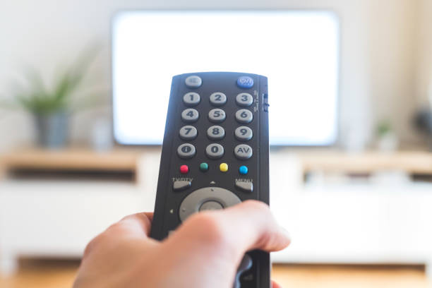 istock Male hand is holding TV remote control, streaming on a smart TV. 1285285952