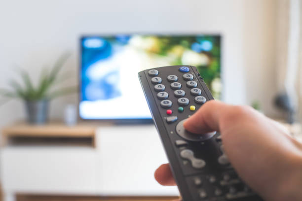 istock Male hand is holding TV remote control, streaming on a smart TV. 1285286255