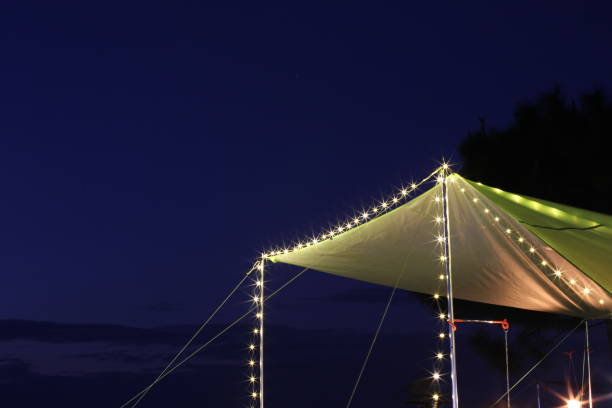 istock Green roof tent lit at night with blue sky background 1285286427