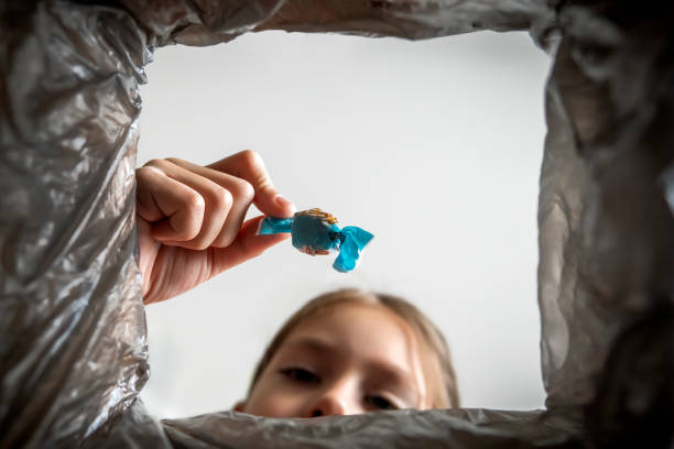 istock refusal of sweets. Girl throws sweet candy in trash 1285288010