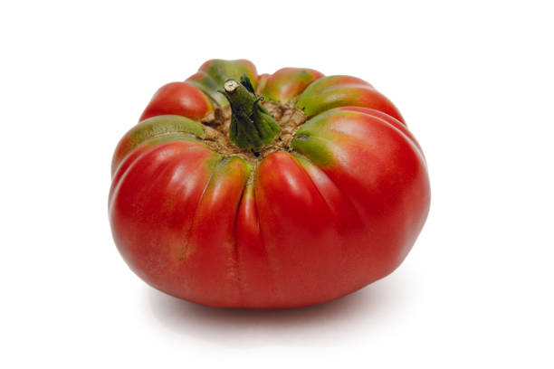 Fresh organically grown German Johnson heirloom tomato isolated on a white background