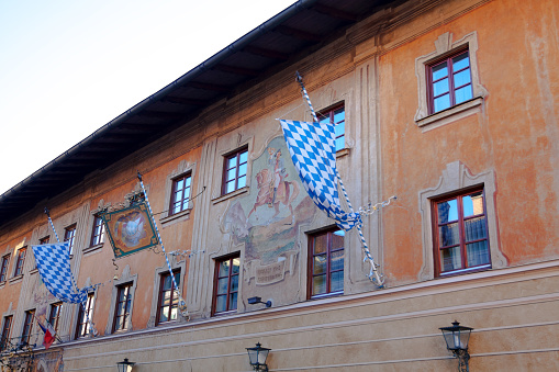 Facade of Hotel Restaurant Post Office in Patenkirchen. At facade are bavarian flags and mural with postillion on horse. Building is from 16th century.