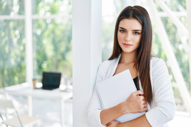 istock Confident business woman holding documents and looking at camera in modern creative office 1285302894