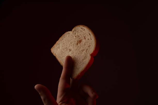 istock Hand holding slice of bread with fingers 1285302992