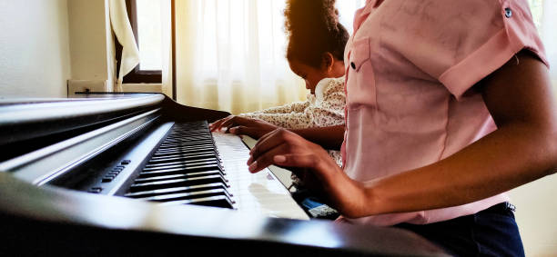 istock Mother is teaching and learning to play the piano at home. 1285304892