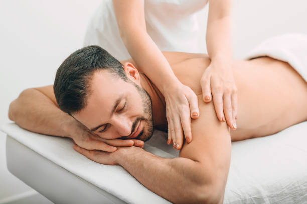 istock handsome man enjoying a back massage, weekend spa. mixed race man relaxes while back massage 1285305549