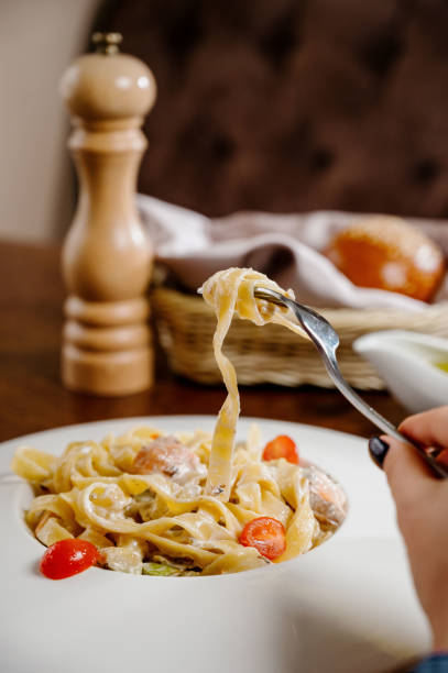 istock Plate with delicious Chicken Alfredo on table 1285307108