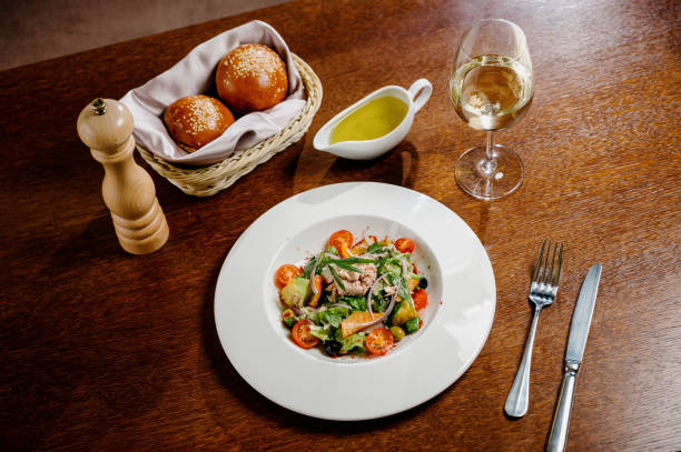 istock Caesar salad with croutons, quail eggs, cherry tomatoes and grilled chicken in wooden table 1285307323