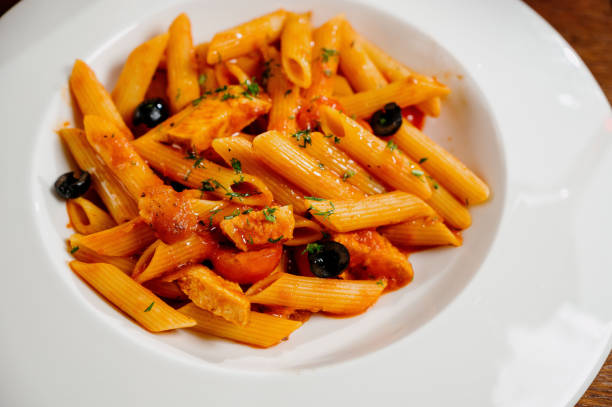 istock Spaghetti pasta with tomatoes and parsley on wooden table 1285307414