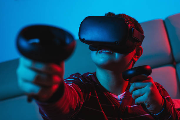 istock Teenager boy using a Virtual reality headset with goggles and hands motion controllers in playing game. 1285307418