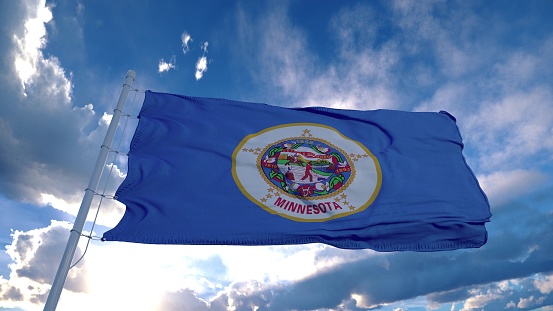 Minnesota flag on a flagpole waving in the wind, blue sky background. 3d rendering.