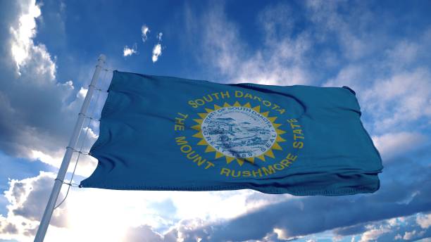 bandera de dakota del sur en un asta de bandera ondeando en el viento, fondo del cielo azul. renderizado en 3d - south dakota fotografías e imágenes de stock