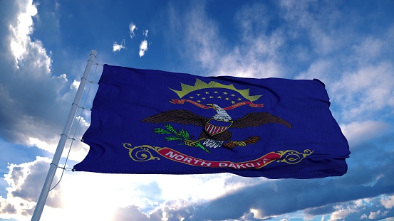 North Dakota flag on a flagpole waving in the wind, blue sky background. 3d rendering.