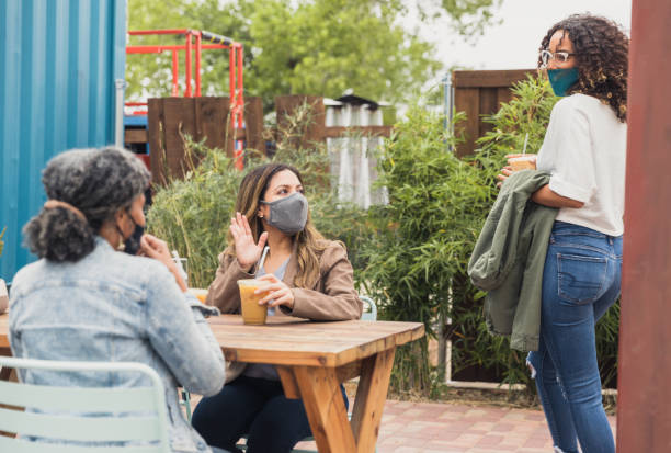 istock Two friends greet woman walking by table 1285308680