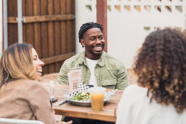 istock Multi-ethnic group of friends smile and laugh during meal 1285308697