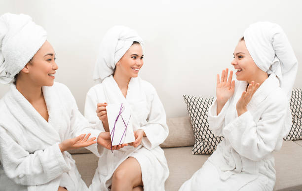 gift card certificate at the spa. women give a certificate to their girlfriend, spa services, body treatments. women in bathrobes enjoying relaxing at the spa - salt room imagens e fotografias de stock