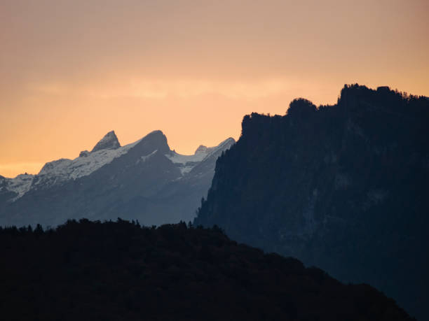 istock Swiss mountain silhouettes at sunrise 1285310345
