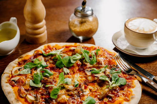 istock Mushroom pizza with addition mozzarella cheese and herbs on a wooden table, top view 1285313262