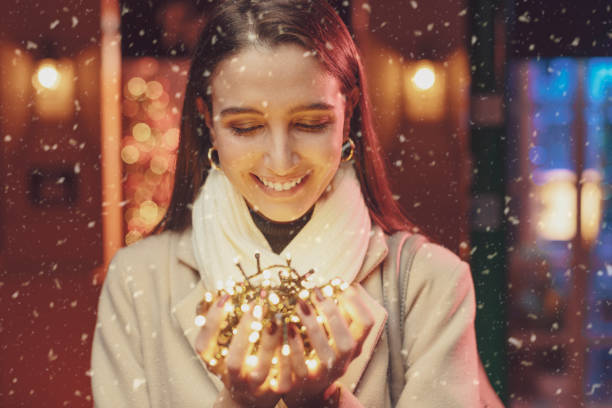 istock Happy woman holding Christmas lights 1285313748