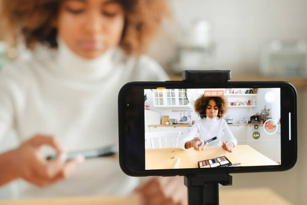 istock Blogger with kinky hair testing brushes against telephone 1285315021