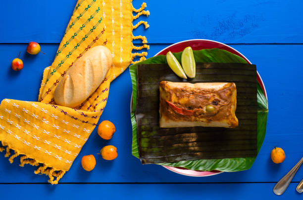 Guatemalan "tamales" Tamales, traditional Guatemalan dish accompanied by bread on a rustic blue wooden table. guatemala stock pictures, royalty-free photos & images