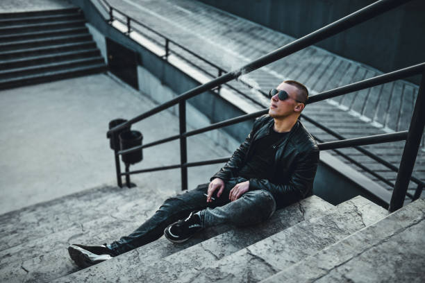 istock Handsome Male Relaxing On Stairs And Smoking Cigarette 1285318536