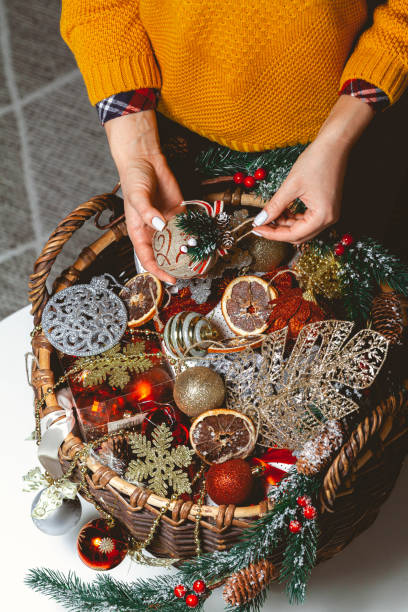 istock Young Woman with a Box Choosing Christmas Decorations in a Baske 1285318552