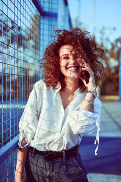 istock Female Talking On Phone While Walking Next To Tennis Court Net 1285318579