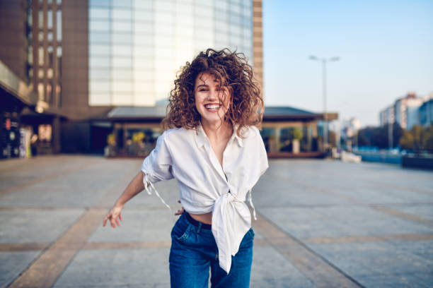 istock Cute Curly Female Walking Through Building Courtyard 1285319778