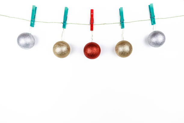 istock Christmas spheres hung with clothespins on a rope on a white background with copy space 1285319992