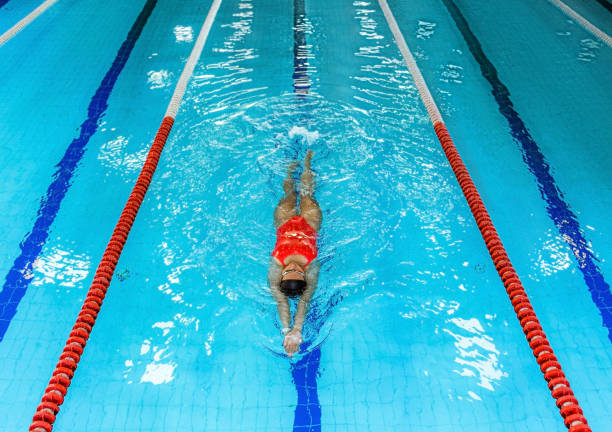 istock Woman swimmer swims backstroke in the pool. Top view, backstroke training 1285321170