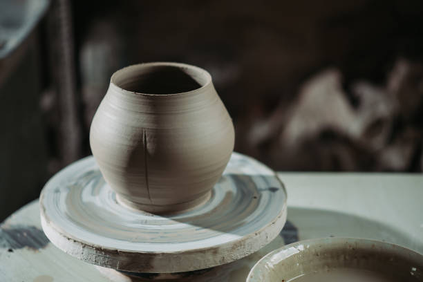 istock Pottery on spinning pottery wheel in clay craft studio 1285321359