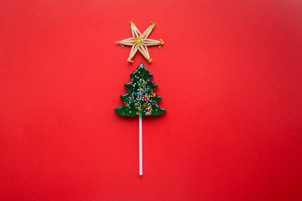istock Christmas tree lollipop on red background with straw star on top 1285325314